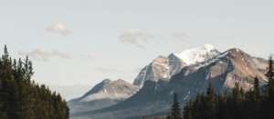 Majestätische Gipfel der Rocky Mountains mit dichten Nadelwäldern – die naturverbundene Kulisse der Werwolf-Fantasy-Reihe Shadowridge Wolves.